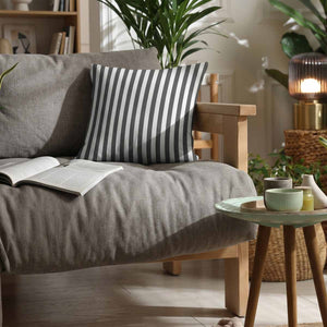A graphite grey and white vertical striped woven cotton scatter cushion on a grey sofa