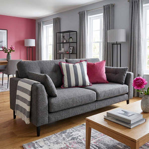 grey and white stripe cushion with pink piping in a living room with pink accent wall and grey sofa
