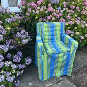 blue and green striped pattern seat pads on a slipcovered outdoor armchair