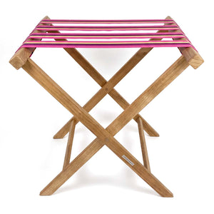 Folding wooden teak luggage rack with Magenta pink, black and yellow stripe cotton webbing straps for hotel guest room