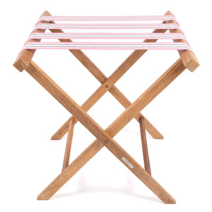 Folding wooden teak luggage rack with soft pink, grey and white stripe cotton webbing straps for hotel guest room