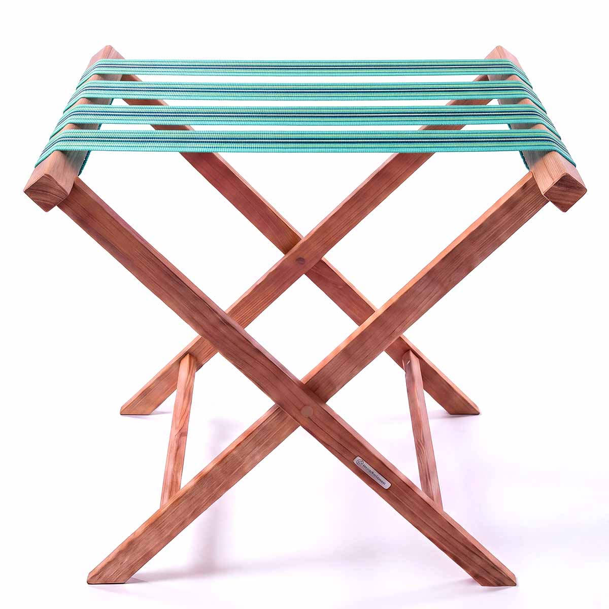 A folding teak wooden luggage rack with turquoise, blue, green and cream stripe cotton webbing straps for hotel guest room