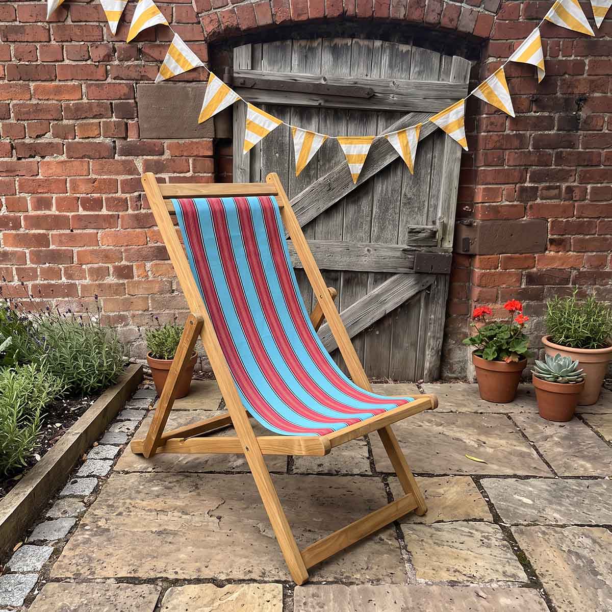 traditional deckchair sky-blue red stripes with bunting on patio