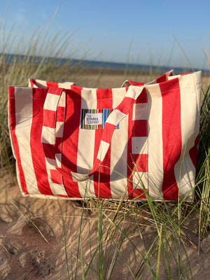 Red and white striped bag on a sandy beach