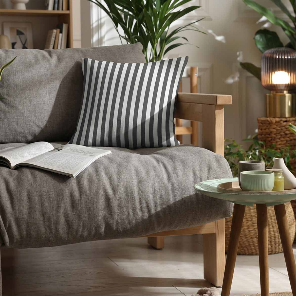 A graphite grey and white vertical striped woven cotton scatter cushion on a grey sofa