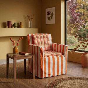 Wide orange and white striped fabric chair cover with coordinated thinner orange and white striped seat pads designed to transform an outdoor wooden directors chair into comfortable indoor seating
