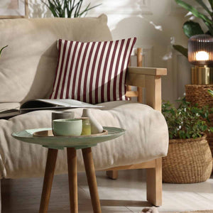 a deep burgundy red and off white striped woven cotton scatter cushion on a cream neutral sofa