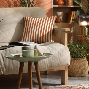 An orange and white candy striped cotton scatter cushion on neutral sofa