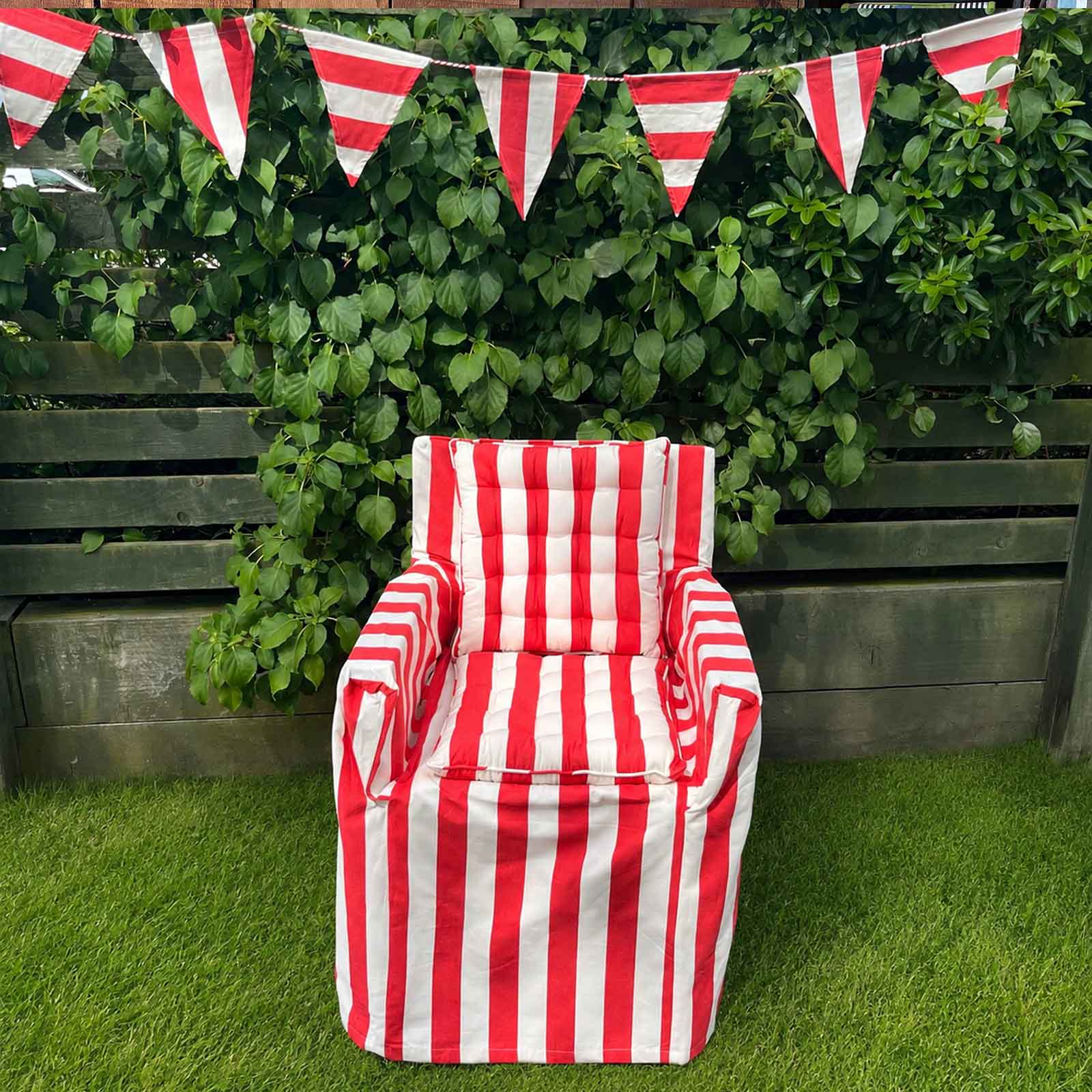 Red and white striped chair  with seat pads in a garden with red and white bunting.