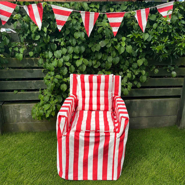 Red and white striped chair  with seat pads in a garden with red and white bunting.