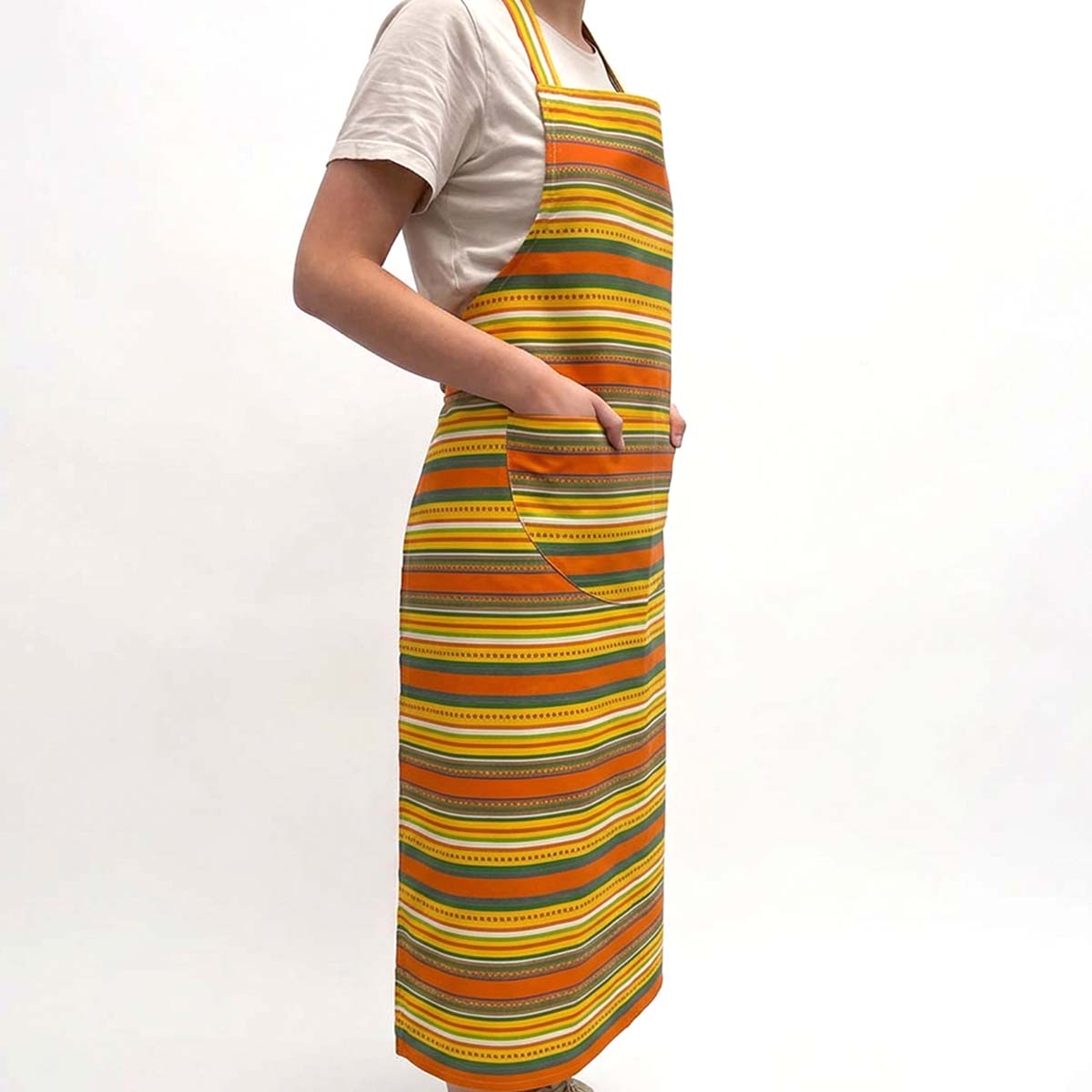 A person wearing a long apron with horizontal stripes in orange, yellow, green, white