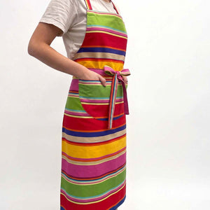 A person wearing a red, green and gold striped apron with a front pocket and waist tie