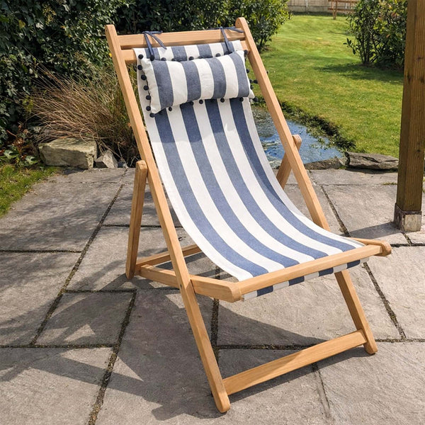 Wooden deck chair with grey and white striped headrest cushion 